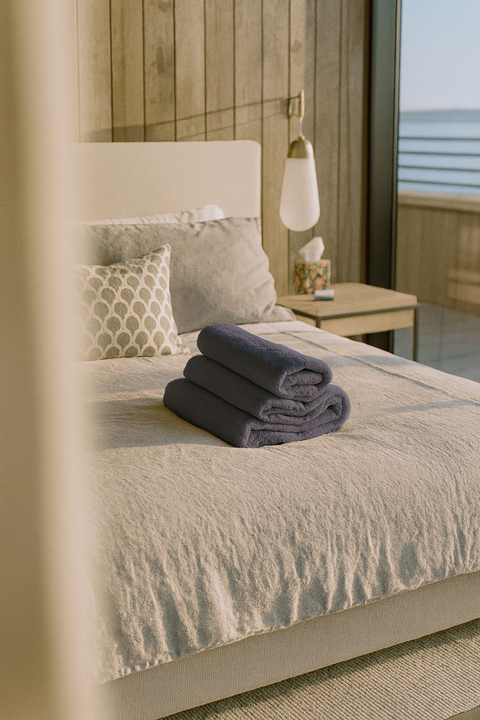 Du linge de lit et des serviettes haut de gamme soigneusement disposés sur un lit immaculé, mettant en valeur les petites attentions qui rendent l’échange de maisons aussi simple que chaleureux.