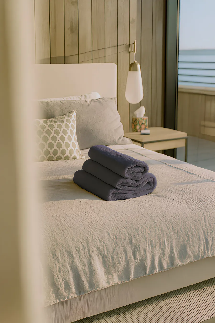 Premium linens and towels placed neatly on a crisp white bed, highlighting the thoughtful amenities provided for a seamless home swapping experience.