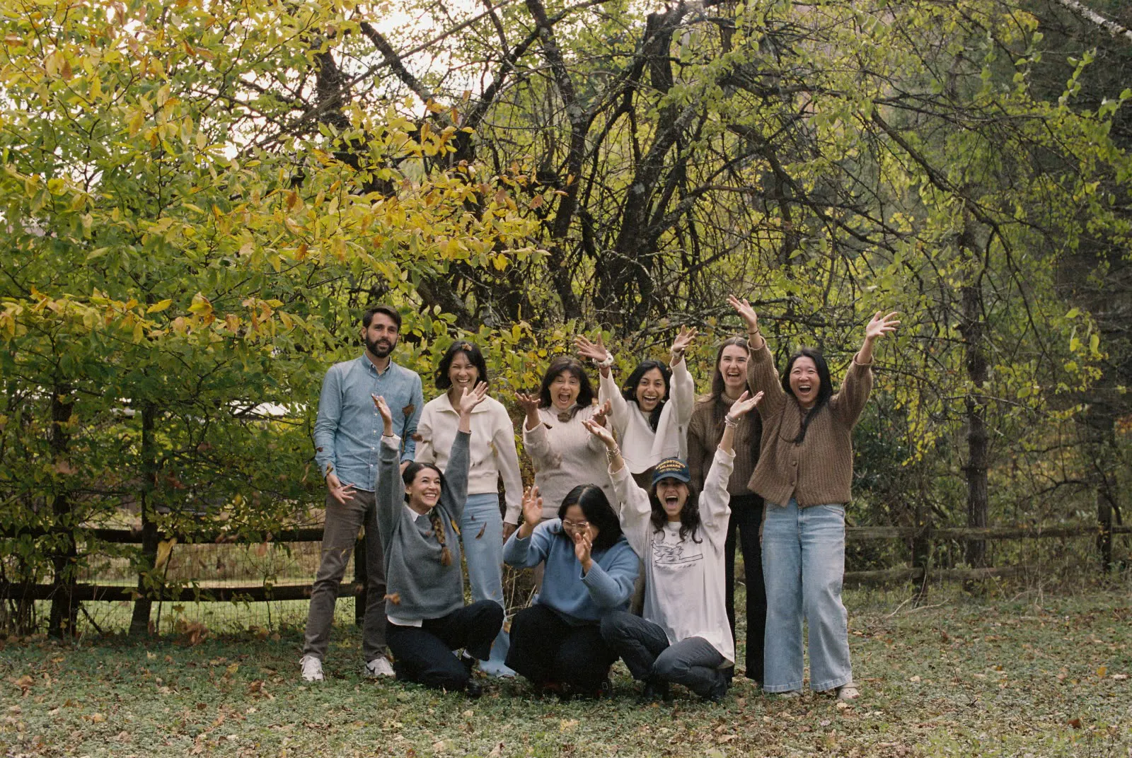 A equipa a festejar sob as árvores de outono, durante o retiro nas Catskills.