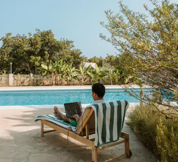 Outdoor workspace by the pool in a Kindred home, perfect for those seeking to blend relaxation with productivity, offering a unique work-from-anywhere experience compared to hotels.