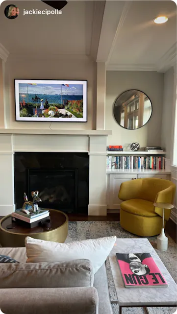 Stylish living room with a fireplace, bookshelves, and vibrant accents, perfect for relaxation during a Kindred stay.