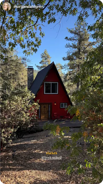 Charming red A-frame cabin surrounded by trees, a tranquil Kindred member’s retreat in nature.