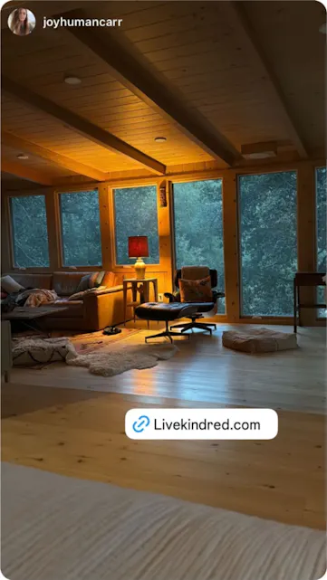 Rustic wood-paneled cabin with large windows and a cozy lounge area, bathed in soft evening light for a peaceful escape.