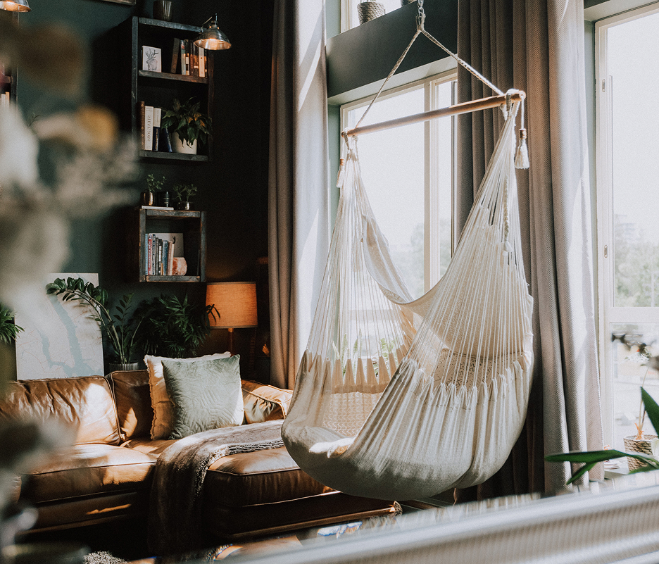 Salon moderne et élégant avec fauteuil hamac et lumière naturelle, conçu pour des échanges de domiciles confortables.