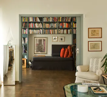 Elegant reading nook with built-in library and sofa, offering a welcoming space for house swap guests.